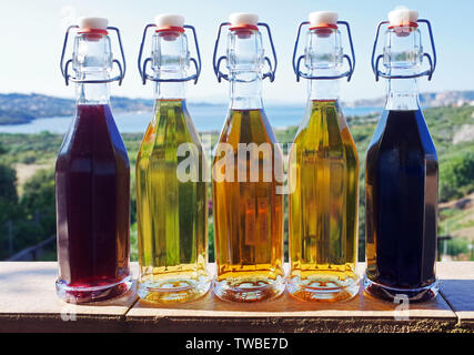 Six colorful glass bottles in front of the sea Stock Photo