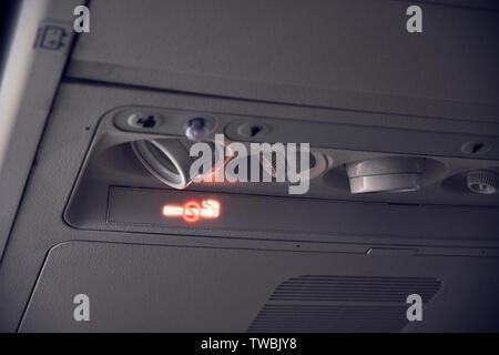 interior view of close up airplane with warning of smoking ban or no smoking flight sign. Stock Photo