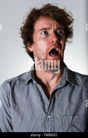 Fear from young man on gray background Stock Photo