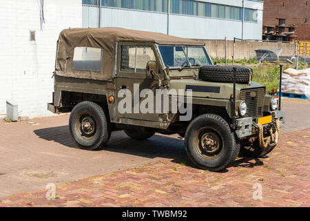 old green army land rover parked in an industrial area Stock Photo