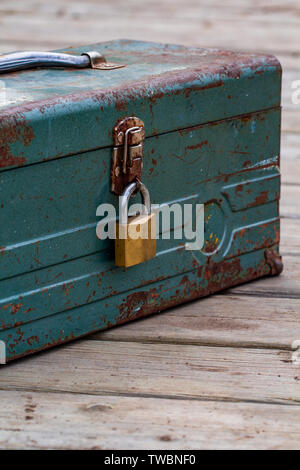 Rusty old toolbox locked up sitting on a wood Stock Photo