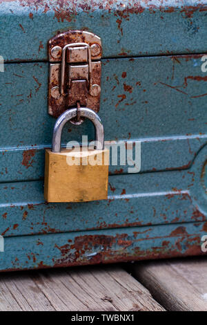 Rusty old toolbox locked up sitting on a wood Stock Photo