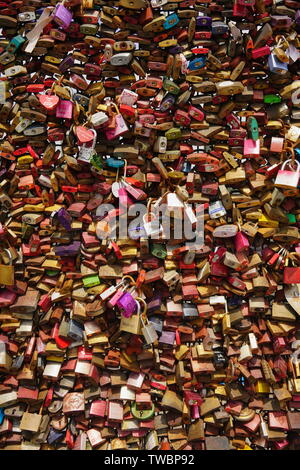 Love locks on Cologne's Hohenzollern Bridge. Thousands of colorful love padlocks decorate the bridge railing atop the river Rhine. Stock Photo