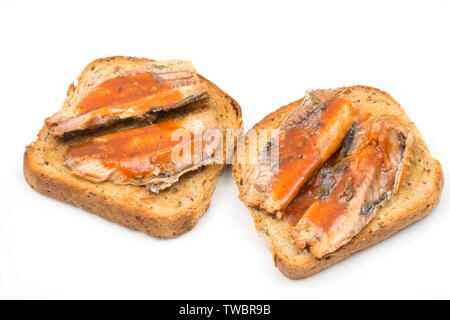 Tinned Asda Smart Price sardines in tomato sauce, caught in the central eastern Atlantic and served on toast. Photographed on a white background. Engl Stock Photo