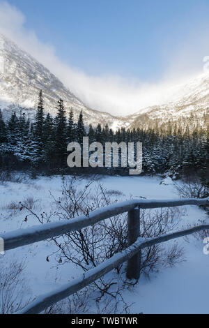 Fence line across snowy landscape Stock Photo - Alamy