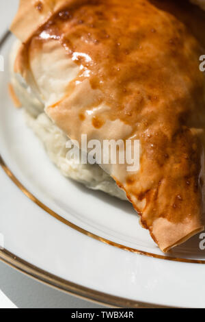 Spanakopita in the shape of a triangle on a plate Stock Photo