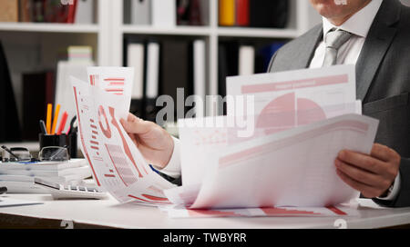 Businessman working and calculating, reads and writes reports. Office employee, table closeup. Business financial accounting concept. Stock Photo