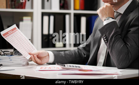 Businessman working and calculating, reads and writes reports. Office employee, table closeup. Business financial accounting concept. Stock Photo
