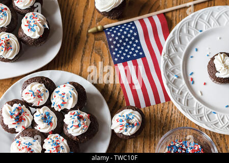 Mini cupcakes flat lay with US flag on wooden table. Stock Photo