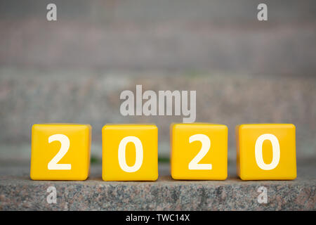 Go further. Yellow 2020 cubes standing on the first stair of the long future path, panorama, copy space Stock Photo