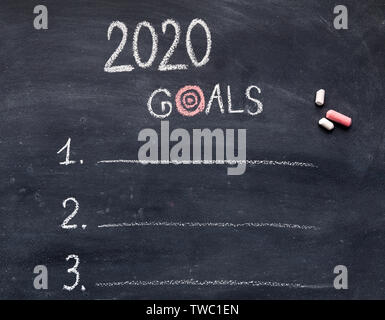 2020 plan concept. New year goals with items hanwriting on chalk board, free space Stock Photo