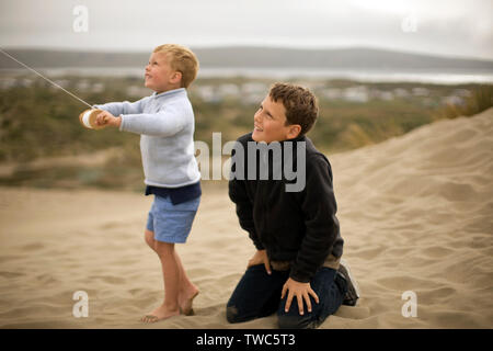 Young boy looks up as he hold a single-string wooden kite reel Stock Photo  - Alamy