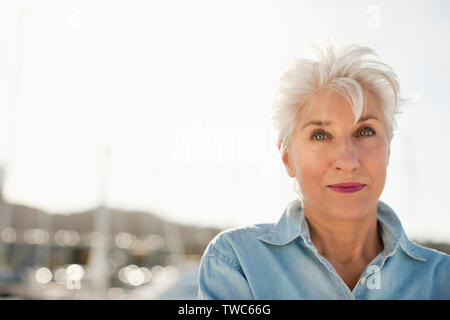 Senior woman wearing pink lipstick poses for a portrait. Stock Photo