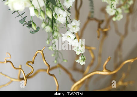 Decoration of the banquet hall, photo zone and wedding arch with eucalyptus leaves, hydrangea and eustoma in the wedding hall. Golden branches. Weddin Stock Photo