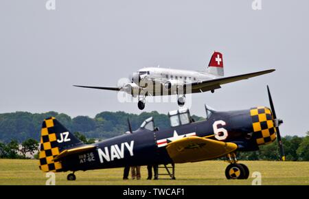 North American AT-6C Harvard IIA and a Swissair Douglas DC-3C at the Daks over Normandy, Duxford airshow on the 4th June 2019 Stock Photo