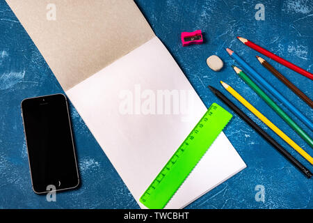 drawing pad and colored pencils on blue background Stock Photo