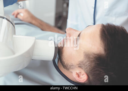 Dentist takes an x-ray picture of the tooth. Patient lying on chair. Dental care concept Stock Photo