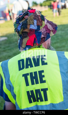 Man wearing a patchwork hat and a Hi-vis jacket with 'Dave the Hat' printed on the back. Stock Photo