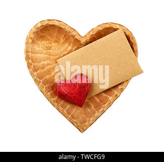 Close up one red painted natural wooden carved heart over brown paper envelope in heart shaped bowl isolated on white background Stock Photo