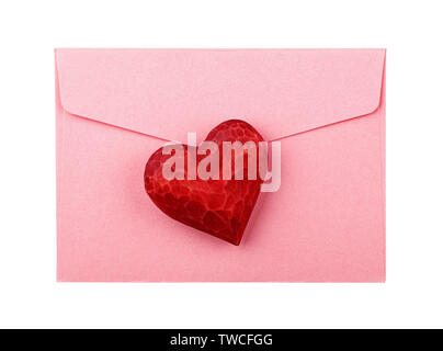 Close up one red painted natural wooden carved heart over pink paper envelope isolated on white background Stock Photo