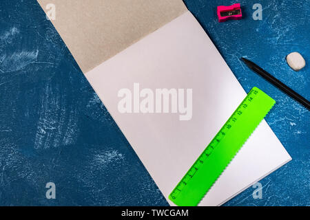 drawing pad and colored pencils on blue background Stock Photo