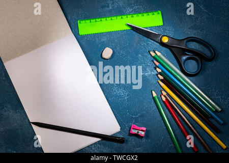drawing pad and colored pencils on blue background Stock Photo