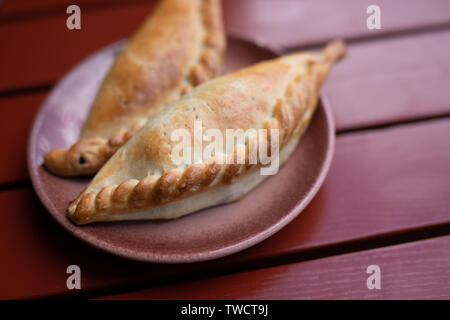 Kibinai, traditional lithuanian food, pastries filled with mutton and onion, popular with Karaite ethnic minority in Trakai, Lithuania. Red background Stock Photo