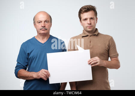 Two mature men holding empty copyspace for ad Stock Photo
