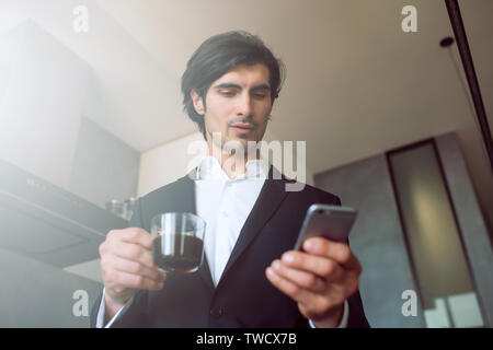 Businessman works with his smartphone at home Stock Photo