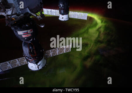 Two docked Russian spaceships, the Soyuz MS-12 crew capsule (foreground) and the Progress 72 resupply ship docked at the International Space Station with the aurora australis or southern lights shining below June 8, 2019 in Earth Orbit. Stock Photo