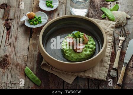 Scallops with pea puree on wooden background, rustic style. Stock Photo