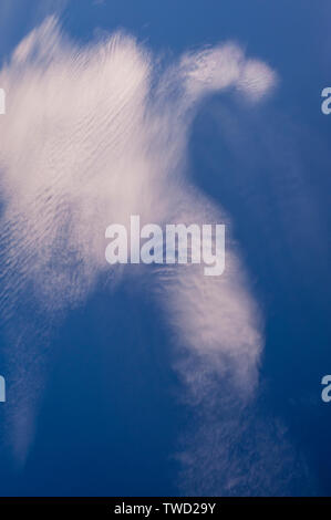 Cirrocumulus clouds in blue sky with abstract shapes and the appearance of motion Stock Photo