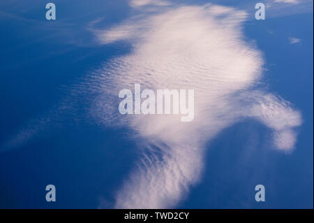 Cirrocumulus clouds in blue sky with abstract shapes and the appearance of motion Stock Photo