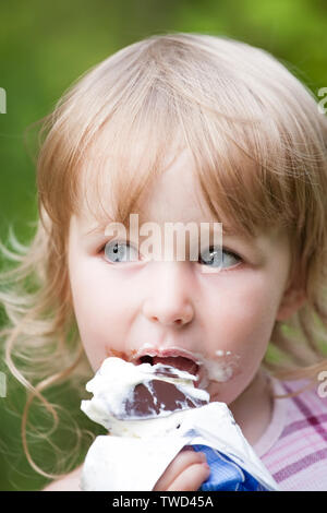 little girl eating chocolate popsicle face closeup Stock Photo