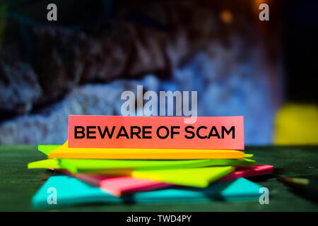 Beware of Scam on the sticky notes with bokeh background Stock Photo