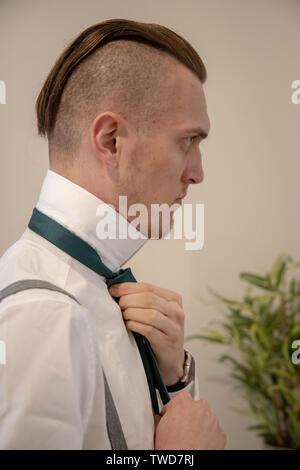 Groom prepares for his Wedding in front of mirror, Jennycliff, Plymouth, Devon, UK Stock Photo