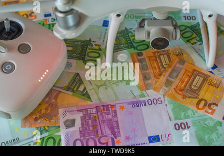 Modern quadcopter with included light indicators. Composition on a background of money. Selective focus. Stock Photo