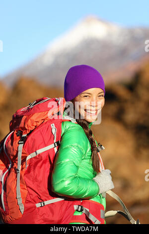 Hiking woman hiker living healthy lifestyle hiking outdoors wearing backpack smiling happy. Beautiful female trekking with looking with aspirations. Mixed race Asian Caucasian girl in her 20s. Stock Photo