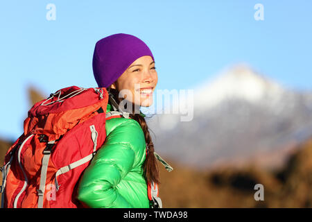Active woman hiker living healthy lifestyle hiking outdoors wearing backpack smiling happy. Beautiful female trekking with looking with aspirations. Mixed race Asian Caucasian girl in her 20s. Stock Photo