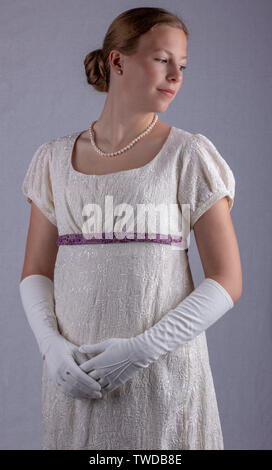 Regency woman in cream dress on studio backdrop Stock Photo