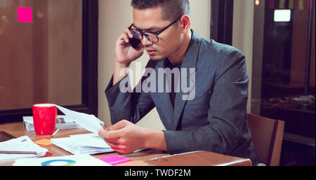 Businessmen and women are using mobile and touch smart phone for Communication and analysis documents on office table Stock Photo