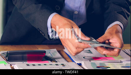 Businessmen count money and plan finances for projects and use calculators for analysis project documents and graph financial diagram working in the b Stock Photo