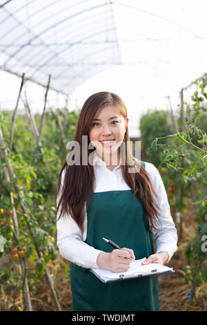 young beautiful asian woman works in green field Stock Photo