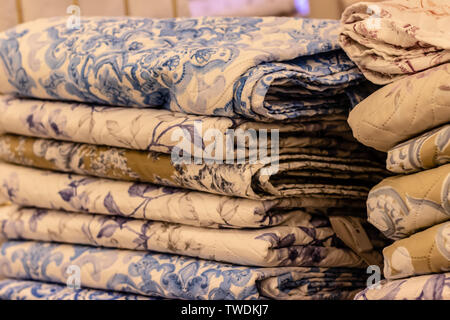 interesting yellow and blue patterned bedsheet pile. photo has taken under white lightning. Stock Photo