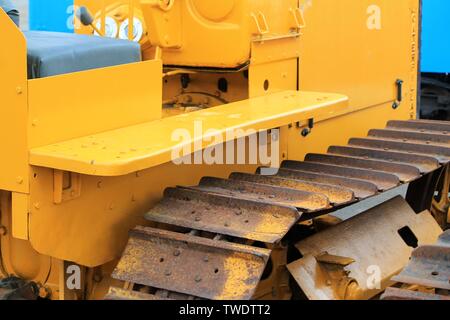 Vintage restored yellow bulldozer with rusted tracks on display at a county fair. This workhorse can really move the Earth. Stock Photo