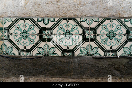 Close up shot of green and white decorative tiles in Lisbon, Portugal. Azulejo is a form of Portuguese and Spanish painted tin-glazed ceramic tiles. Stock Photo