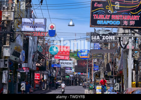 Notorious entertainment area Walking Street, Pattaya, Thailand, full of signboards advertising bars, and looking fairly unglamorous in bright daylight Stock Photo