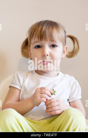 closeup face portrait of funny two years old blonde white girl on wall backgroundcloseup face portrait of funny two years old blonde white girl on stu Stock Photo