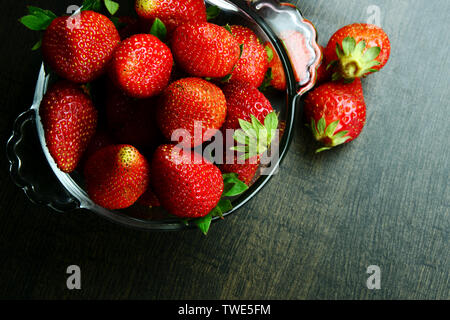 Fresh, ripe and juicy strawberry fruits in a bowl with a glass of strawberry shake or smoothy Stock Photo