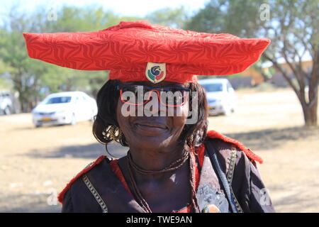 04 June 2019, Namibia, Okahandja: A Herero woman wears the traditional costume of her tribe during a visit to a cemetery in Okahandja, a town north of the Namibian capital Windhoek. The women of the Herero - traditionally a people of cattle herders - wear a bulky hat in their traditional costume, the shape of which is supposed to remind us of cattle horns. Photo: Jürgen Bätz/dpa Stock Photo